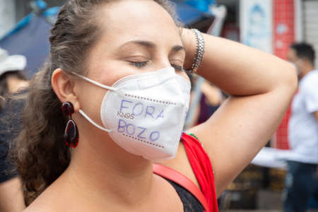 Salvador, Bahia, Brazil - July 24, 2021: People protest against the government of President Jair Bolsonaro in the city of Salvador. They use banners, posters, stickers and masks with slogans.のeditorial素材