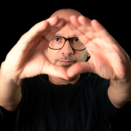 Portrait of a bearded man wearing eyeglasses against a black background. Salvador, Bahia, Brazil.の写真素材