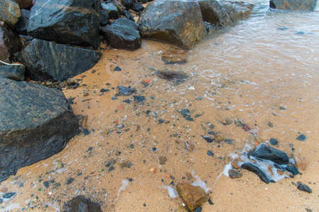 Rough sea crashing on the beach rocks. Rio Vermelho, Salvador, Bahia, Brazil.の写真素材