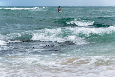 Ocean waves breaking on the sands of the famous Rio Vermelho beach. City of Salvador, Bahia, Brazil.