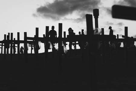 Silhouette of people and crosses fixed on the ground in honor of those killed by covid-19. Sunset in Salvador, Bahia, Brazil.の写真素材