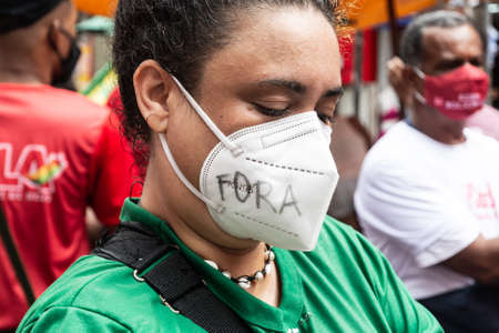 Salvador, Bahia, Brazil - July 24, 2021: People protest against the government of President Jair Bolsonaro in the city of Salvador. They use banners, posters, stickers and masks with slogans.のeditorial素材