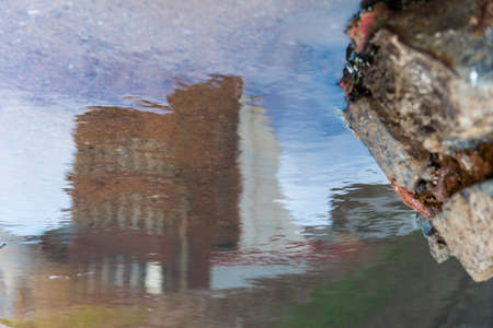 Reflection of buildings through a pool of water on the ground. City of Salvador, Bahia, Brazil.の写真素材