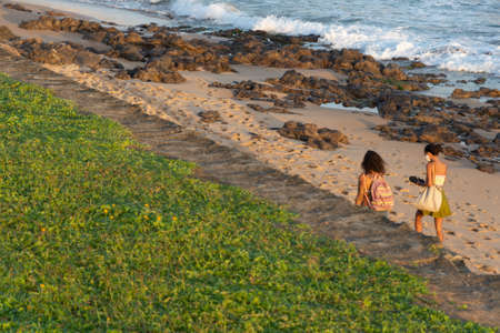 Salvador, Bahia, Brazil - September 05, 2021: Two women walking on the sand of Paciencia beach in Rio Vermelho neighborhood in Salvador, Brazil.のeditorial素材