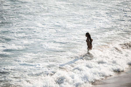 Salvador, Bahia, Brazil - September 05, 2021: A person entering the sea from Praia da Paciencia in Salvador, Bahia, Brazil.のeditorial素材