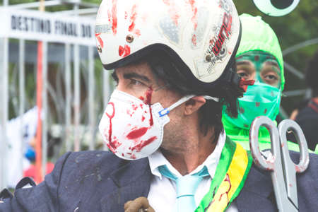 Salvador, Bahia, Brazil - July 24, 2021: People protest against the government of President Jair Bolsonaro in the city of Salvador. They use banners, posters, stickers and masks with slogans.のeditorial素材