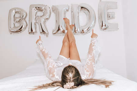 Woman lying in bed against white background written Bride. Salvador, Bahia, Brazil.の写真素材