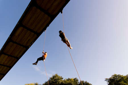 Salvador, Bahia, Brazil - September 17, 2019: Two women practicing rappel on a pedestrian walkway.