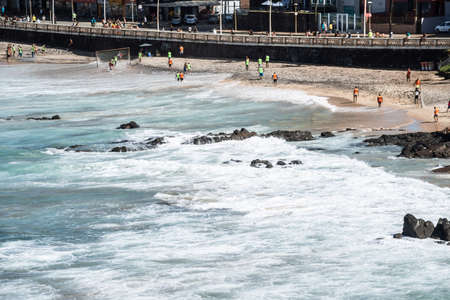 Salvador, Bahia, Brazil - August 15, 2021: View from the top of a beach with several people in the...