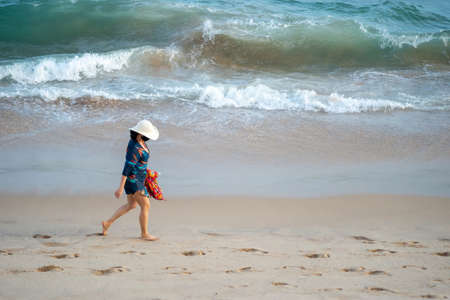 Salvador, Bahia, Brazil - September 26, 2021: Woman walking on the sand of Farol da Barra beach in Salvador city, Bahia state, Brazil.のeditorial素材