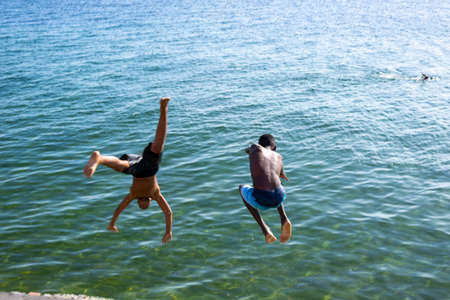 Salvador, Bahia, Brazil - December 31, 2021: Young jumpers jumping from Boa Viagem beach pier in Salvador city, capital of Bahia, Brazil.のeditorial素材