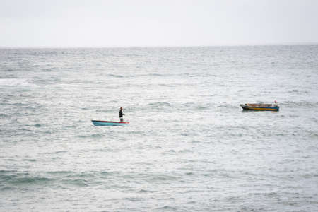 A man in a fishing boat on the beach of the Rio Vermelho. City of Salvador, Bahia, Brazil.のeditorial素材