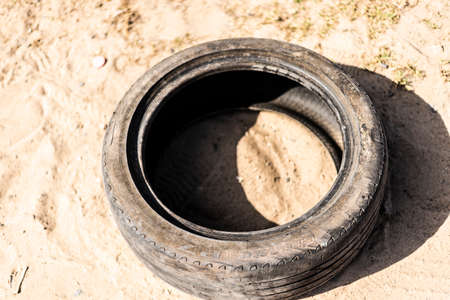 Portrait of a bad old tire lying on the sand floor. City of Salvador in the Brazilian state of Bahia.の写真素材