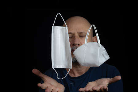 Portrait of two protective masks against and a man counts on black background. Salvador, Bahia,...