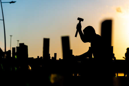 Salvador, Bahia, Brazil - October 01, 2021: Silhouette of a man fixing crosses on the ground in honor of those killed by covid-19. Barra Lighthouse, Salvador, Bahia, Brazil.のeditorial素材