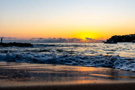 Dramatic sunset on the beach with vibrant colors. Salvador, Bahia, Brazil.