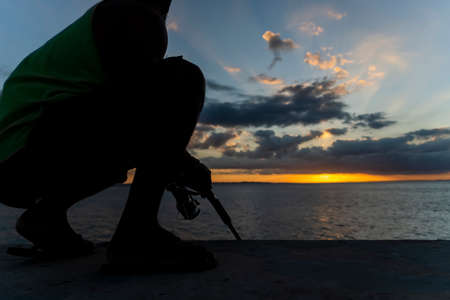 Salvador, Bahia, Brazil - May 23, 2021: Silhouette of people at sunset with dramatic. City of Salvador, Bahia, Brazil.の写真素材