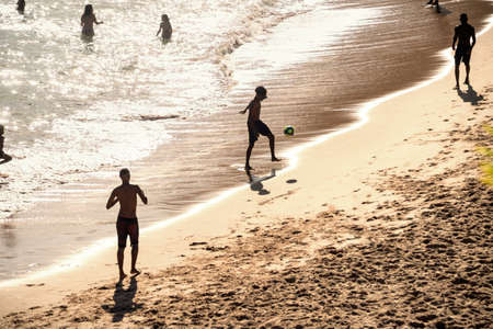 Salvador, Bahia, Brazil - November 01, 2021: People at PaciÃªncia beach in Salvador having fun walking and playing beach soccer.のeditorial素材