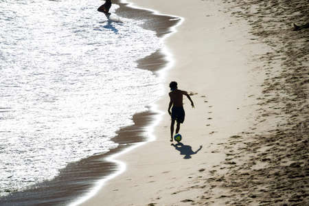 Salvador, Bahia, Brazil - November 01, 2021: People at PaciÃªncia beach in Salvador having fun walking and playing beach soccer.のeditorial素材