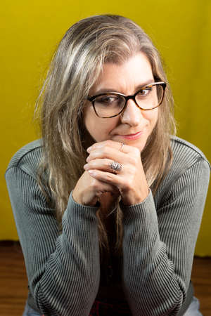 Portrait of a woman wearing eyeglasses against yellow background. Salvador Bahia Brazil.の写真素材
