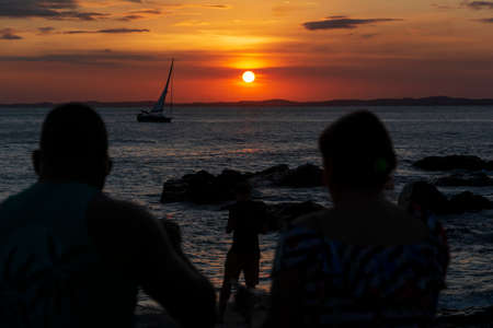 Salvador, Bahia, Brazil - September 20, 2020: Silhouette of people at sunset with dramatic. City of Salvador, Bahia, Brazil.の写真素材