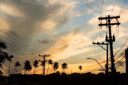 Silhouette of buildings, houses, poles, wires and trees against dramatic sunset. City of Salvador, Bahia, Brazil.の写真素材