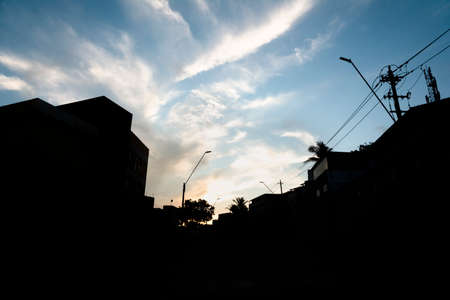 Silhouette of buildings, poles and wires against dramatic sunset. City of Salvador, Bahia, Brazil.の写真素材
