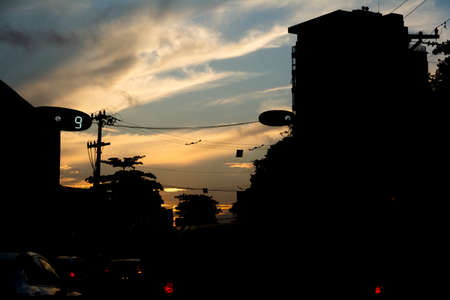 Silhouette of buildings, houses, poles, wires and trees against dramatic sunset. City of Salvador, Bahia, Brazil.の写真素材