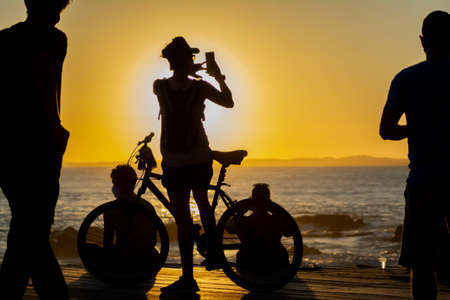 Salvador, Bahia, Brazil - September 18, 2020: Silhouette of people at sunset with dramatic. City of Salvador, Bahia, Brazil.の写真素材