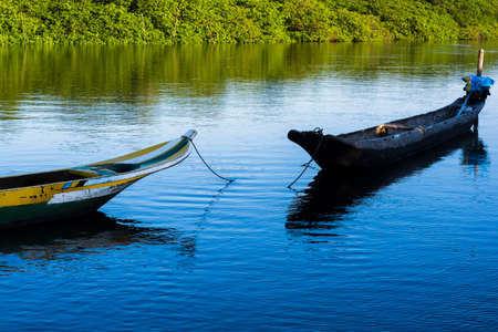 Canoes and boats docked on the Jaguaripe River in Maragogipinho, Aratuipe city in Bahia, Brazil.の写真素材