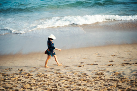 Salvador, Bahia, Brazil - September 26, 2021: Woman walking on the sand of Farol da Barra beach in Salvador city, Bahia state, Brazil.のeditorial素材