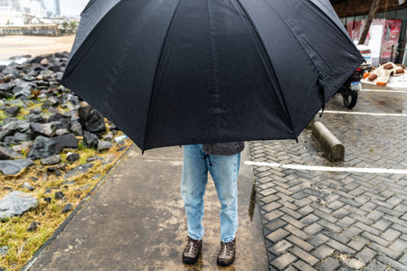 Salvador, Bahia, Brazil - November 15, 2021: Lower part of a woman with an umbrella. Salvador, Bahia, Brazil.のeditorial素材