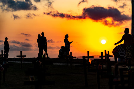 Salvador, Bahia, Brazil - October 01, 2021: Silhouette of people and crosses fixed on the ground in honor of those killed by covid-19. Sunset in Salvador, Bahia, Brazil.のeditorial素材
