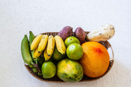Fruits in a wooden basket against white background. Salvador, Bahia, Brazil.