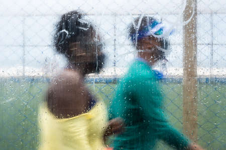 Silhouettes of people passing behind wet glass from the rain. Salvador, Bahia, Brazil.の写真素材
