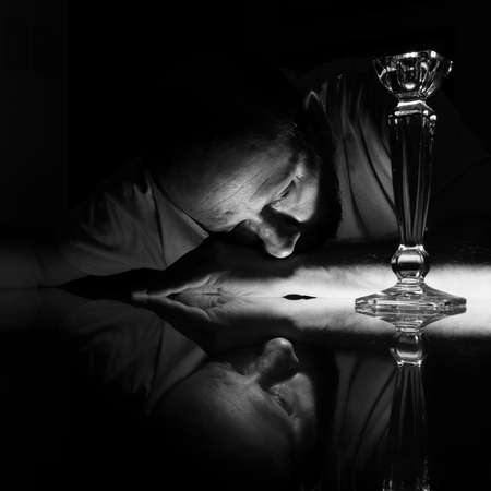 Black and white closeup of man face lying on glass with reflection. Salvador, Bahia, Brazil.の写真素材