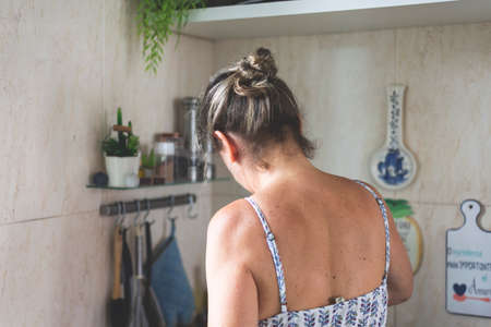 Young woman from the back making food in the kitchen.の写真素材