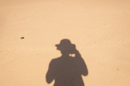 Human shadow on the beach sand. City of Salvador, Bahia, Brazil.