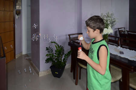 Portrait of a child blowing soap bubbles. Salvador, Bahia, Brazil.の写真素材
