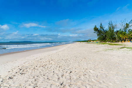 Clear and dense sand against blue sky with clouds and strong sun on Guaibim beach in Valenca city in Bahia, Brazil.の写真素材