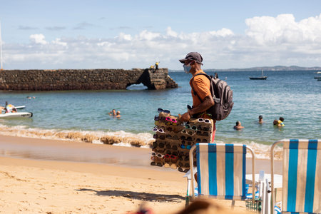 Salvador, Bahia, Brazil - June 04, 2022: Street vendors walk on the sand of Porto da Barra beach in Salvador, Bahia.のeditorial素材