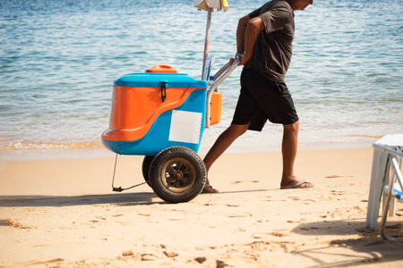 Salvador, Bahia, Brazil - June 04, 2022: Street vendors walk on the sand of Porto da Barra beach in Salvador, Bahia.のeditorial素材