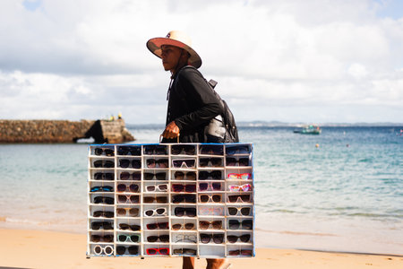 Salvador, Bahia, Brazil - June 04, 2022: Street vendors walk on the sand of Porto da Barra beach in Salvador, Bahia.のeditorial素材