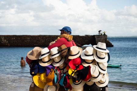 Salvador, Bahia, Brazil - June 04, 2022: Street vendors walk on the sand of Porto da Barra beach in Salvador, Bahia.のeditorial素材
