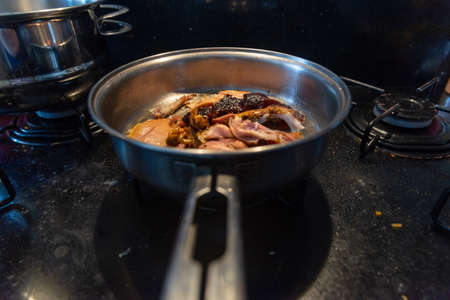Chicken meat frying in the pan on top of the stove. Salvador, Bahia, Brazil.の写真素材