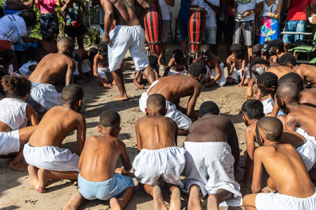 Santo Amaro, Bahia, Brazil - July 24, 2022: Members of the cultural event Nego Fugido sing and sit on the ground for the end of slavery in Acupe, Santo Amaro, Bahia.のeditorial素材