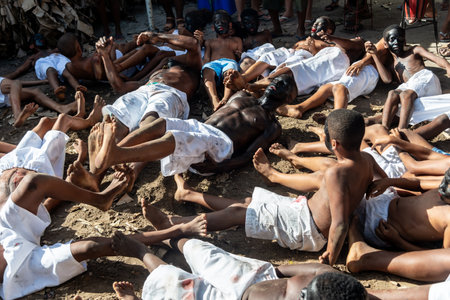 Santo Amaro, Bahia, Brazil - July 24, 2022: Members of the cultural manifestation Nego Fugido lying on the ground for the end of slavery in Acupe, Santo Amaro, Bahia.のeditorial素材