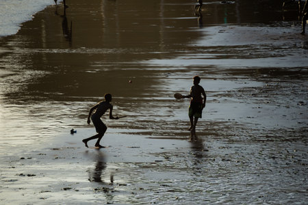 Salvador, Bahia, Brazil - November 01, 2021: Two young men playing beach soccer at Rio Vermelho beach in Salvador, Bahia in the late afternoon.のeditorial素材