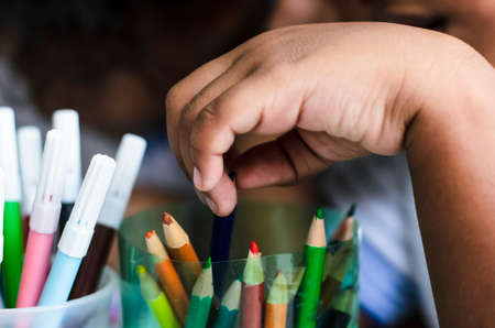 Salvador, Bahia, Brazil - December 16, 2014: Detail of student hands painting writing with colored pencils. Salvador, Bahia, Brazil.の写真素材