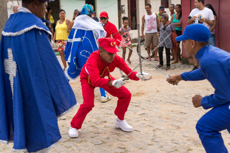 Saubara, Bahia, Brazil - August 03, 2019: Men, women and children, members of the cultural group CheganÃ§a dos Marujos, dance and sing in costumes during a performance at the streets of Saubara, Bahia.のeditorial素材